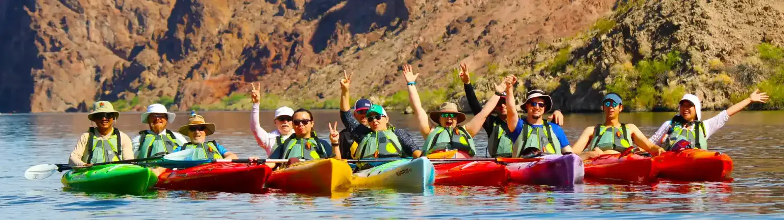 Large group of kayakers celebrating on the Colorado River