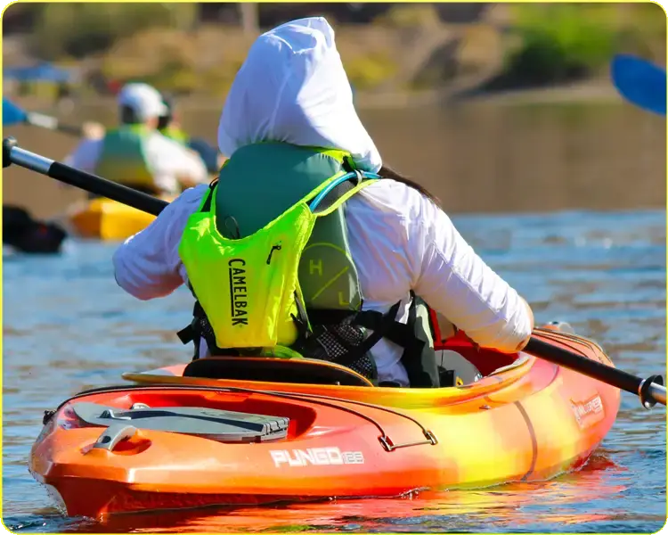 Kayakers paddling colorful boats on the river